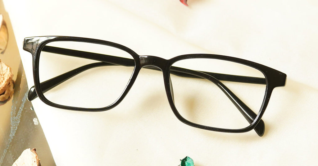 Poney Eyeglasses - Black placed on the table
