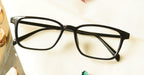 Poney Eyeglasses - Black placed on the table