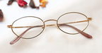 Assiduous Eyeglasses - Golden placed on the table