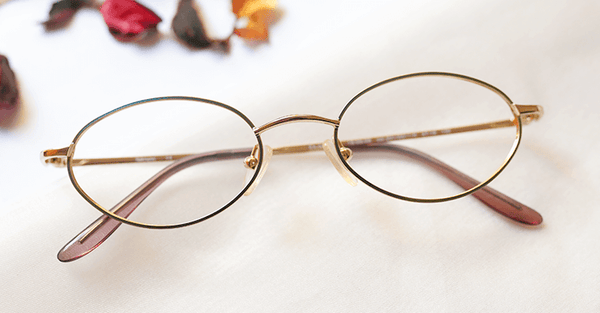 Assiduous Eyeglasses - Golden placed on the table