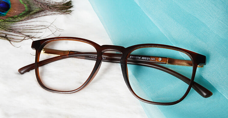 Exquisite blue cut brown eyeglasses placed on blue and white fabric