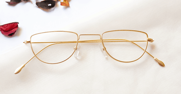 Blossom Eyeglasses - Golden placed on the table