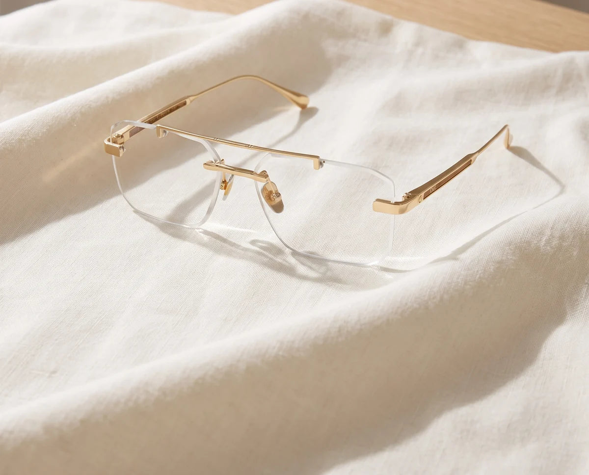 Light as Nothing. Gold rimless glasses resting on ivory linen.