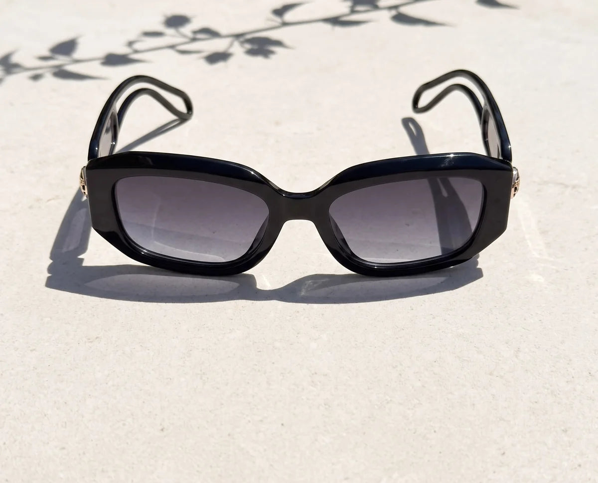 Vellum black angular sunglasses with grey gradient lenses on sunlit limestone.