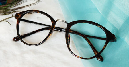 Dignity blue cut brown eyeglasses placed on blue and white fabric