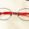 Epopeia Eyeglasses - Black and Red placed on the table